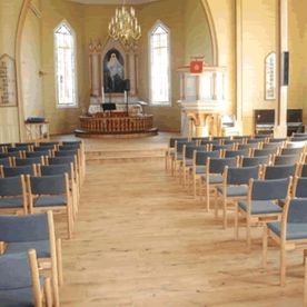 Stoler Moster kirke på rekke og rad med grå seter og rygg i stoff