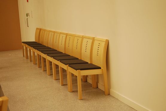 Finera barnestoler med stoff seter som står langs en vegg