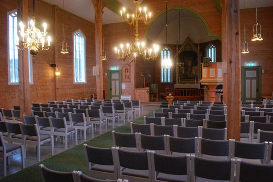 Grå stoler på rekke og rad inne i Sæbø kirke