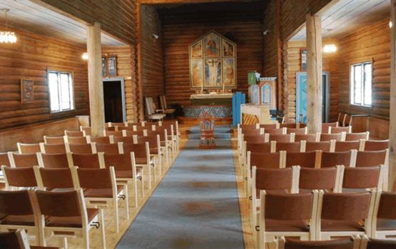 Stoler med brune seter og rygg på rekke og rad inne i Skoklefall kirke