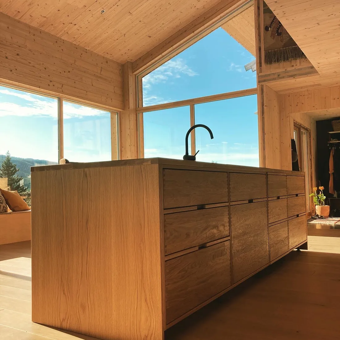 Moderne kjøkkenøy i lys eik i en lys og moderne bolig med masse vindu som slipper inn mye naturlig lys