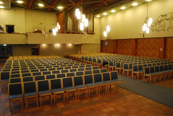 Finera stoler på rekke og rad inne i Tosen kirke tatt slik at man ser stolene vendt mot seg og et kirkeorgel i bakgrunnen